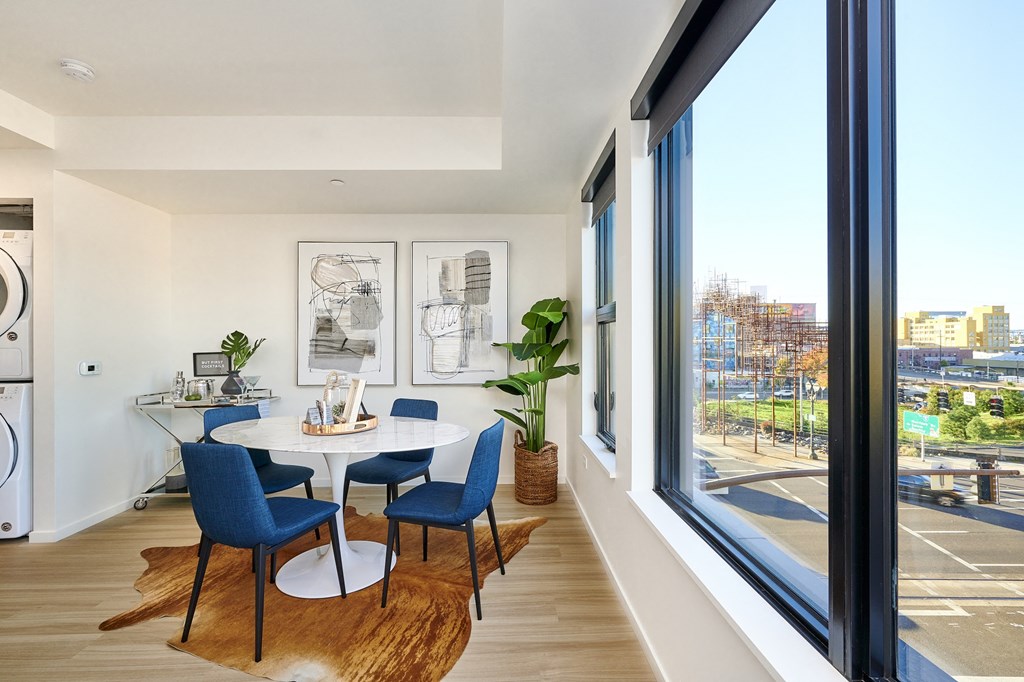 a dining room with a table and chairs and a large window