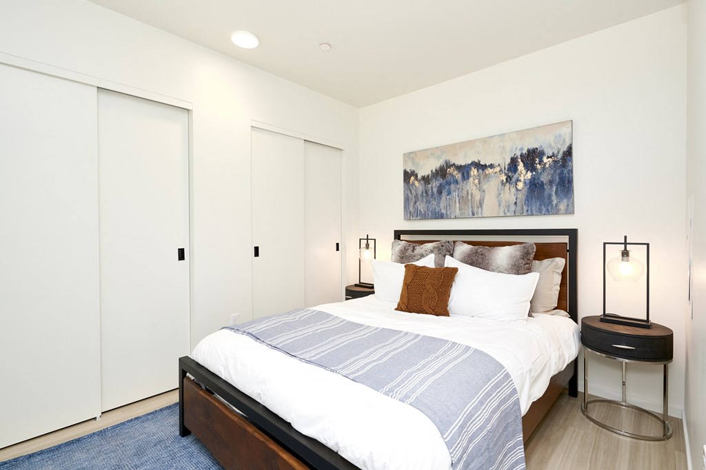 a bedroom with a large bed and white closets
