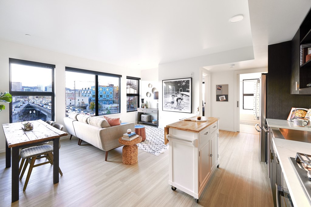 a living room with a kitchen and a view of the city