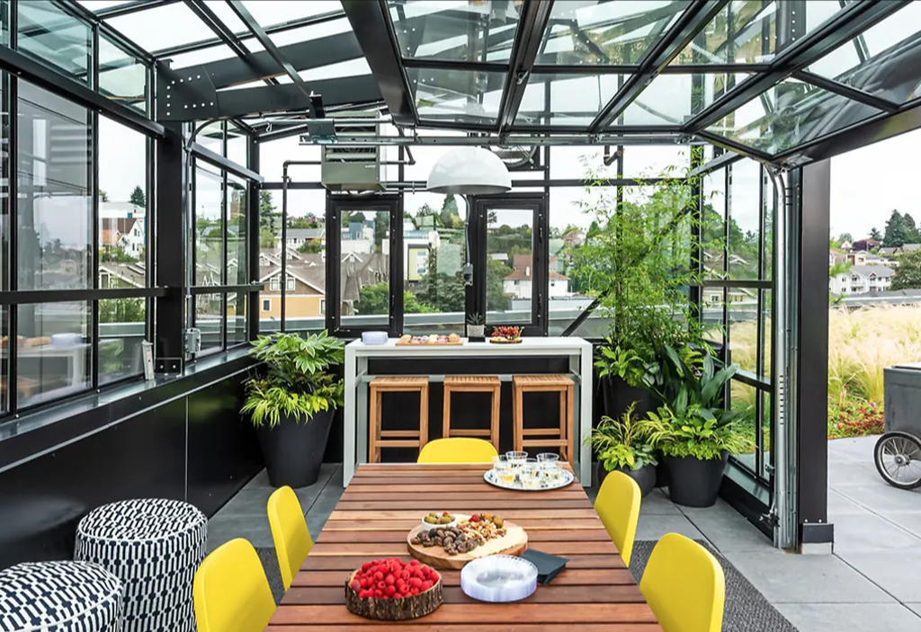 A plant lovers dream! Showing a greenhouse with dining table and plants inside. Great space for entertaining.
