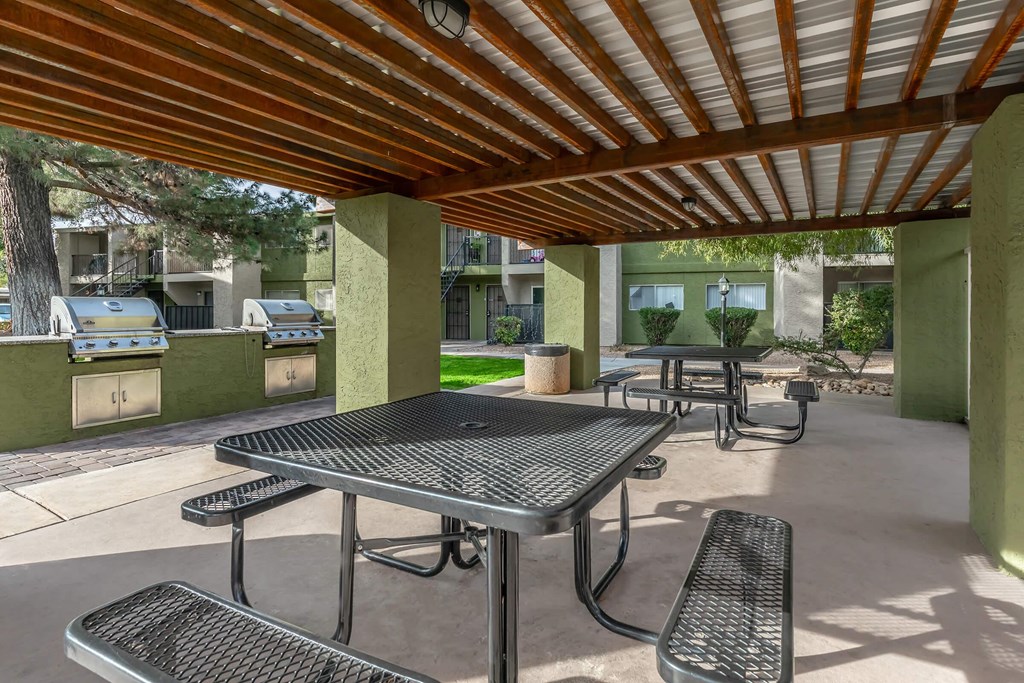 A patio with a table and chairs under a roof.