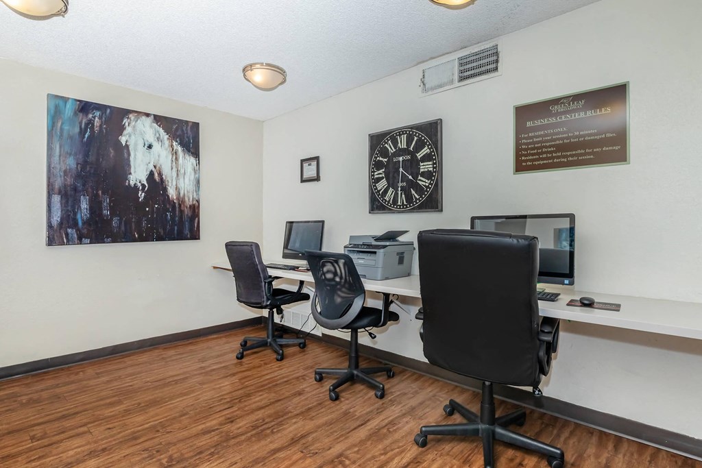 A room with two chairs and a desk with a computer on it.