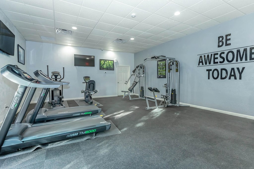 A gym with treadmills and a wall that says "Be Awesome Today".
