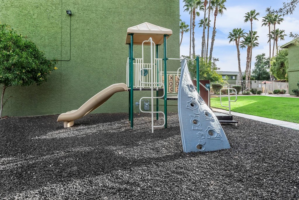A playground with a slide and a climbing frame.