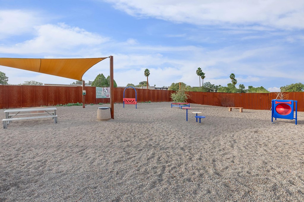 A sandy volleyball court with a net, bench, and ball.