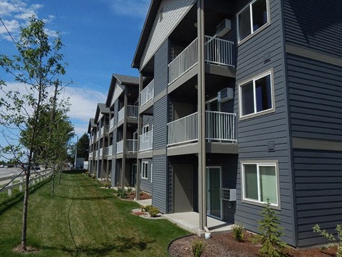 a row of buildings with balconies and grass