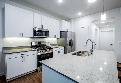 A kitchen with white cabinets and a granite countertop.