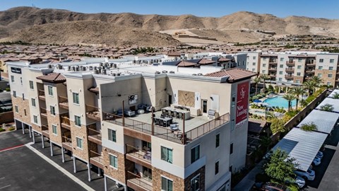 Apartment complex with a pool and a mountain in the background.