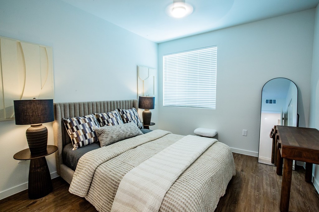 A bedroom with a large bed and a wooden table.