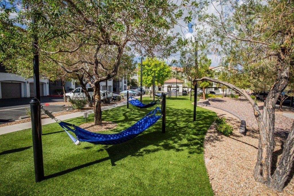 Colton Apartments A blue hammock is suspended between two poles in a grassy area.