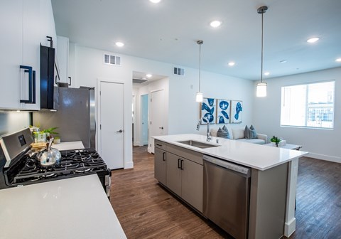 A modern kitchen with a stove top oven and a refrigerator.