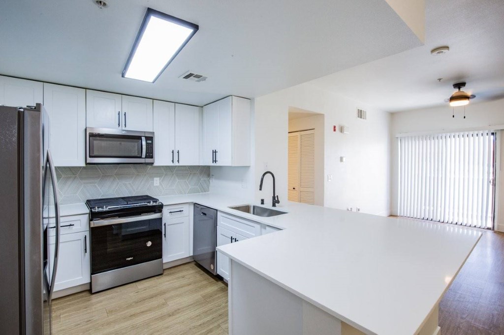 A kitchen with white cabinets and a white counter top.