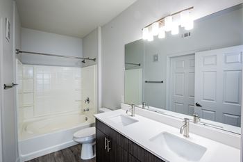 A white bathroom with a white tub and toilet.