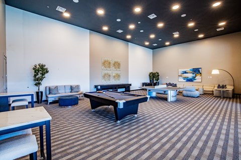 A room with a pool table and a couch.