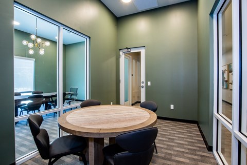 A conference room with a round table and chairs.