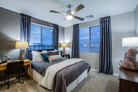 A bedroom with a bed, desk, and chair.