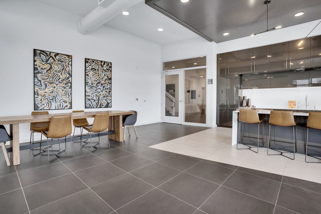 A modern dining room with a long table and chairs.