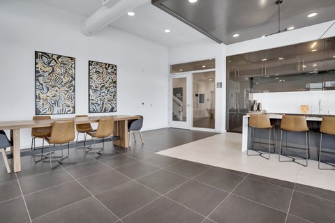 A modern dining room with a long table and chairs.