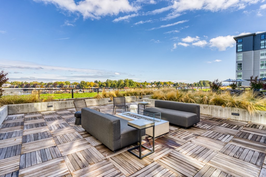 A wooden deck with a table and chairs overlooking a cityscape.