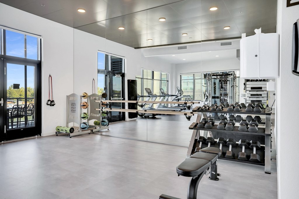 A gym with a variety of equipment including weights and machines.