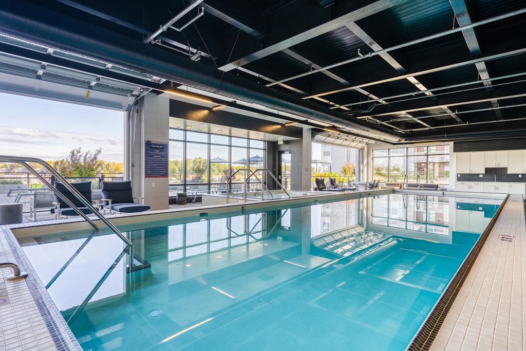 A large indoor swimming pool with a glass ceiling and a view of the outdoors.