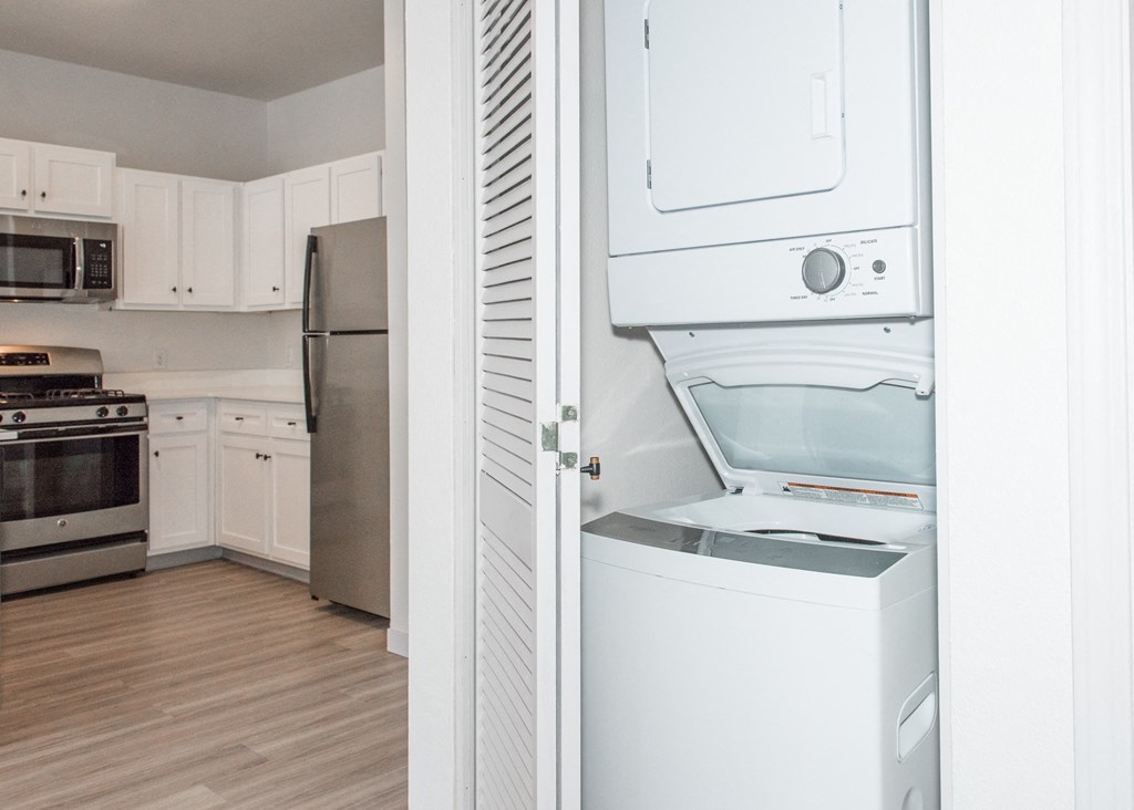 a kitchen with white cabinets and a white washer and dryer