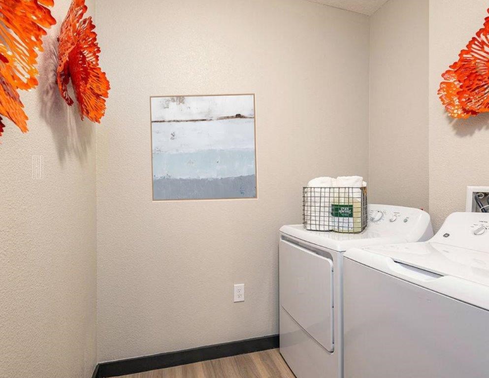 a washer and dryer in a room with a painting on the wall