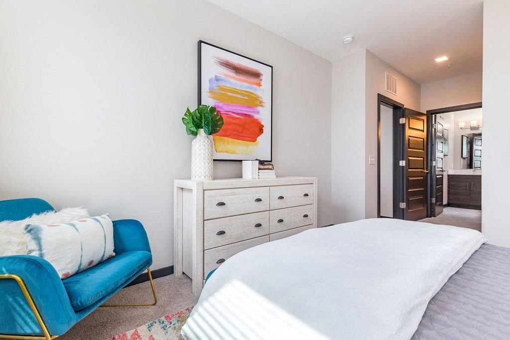 a bedroom with a white bed and a blue chair