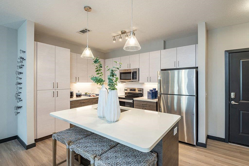 a kitchen with a refrigerator freezer next to a stove top oven