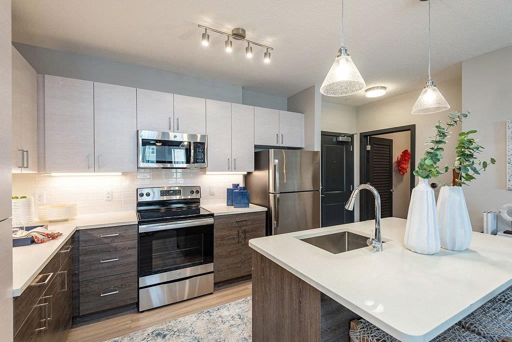a kitchen with a sink stove refrigerator and microwave