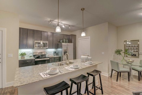 an open kitchen and dining area with a marble counter top