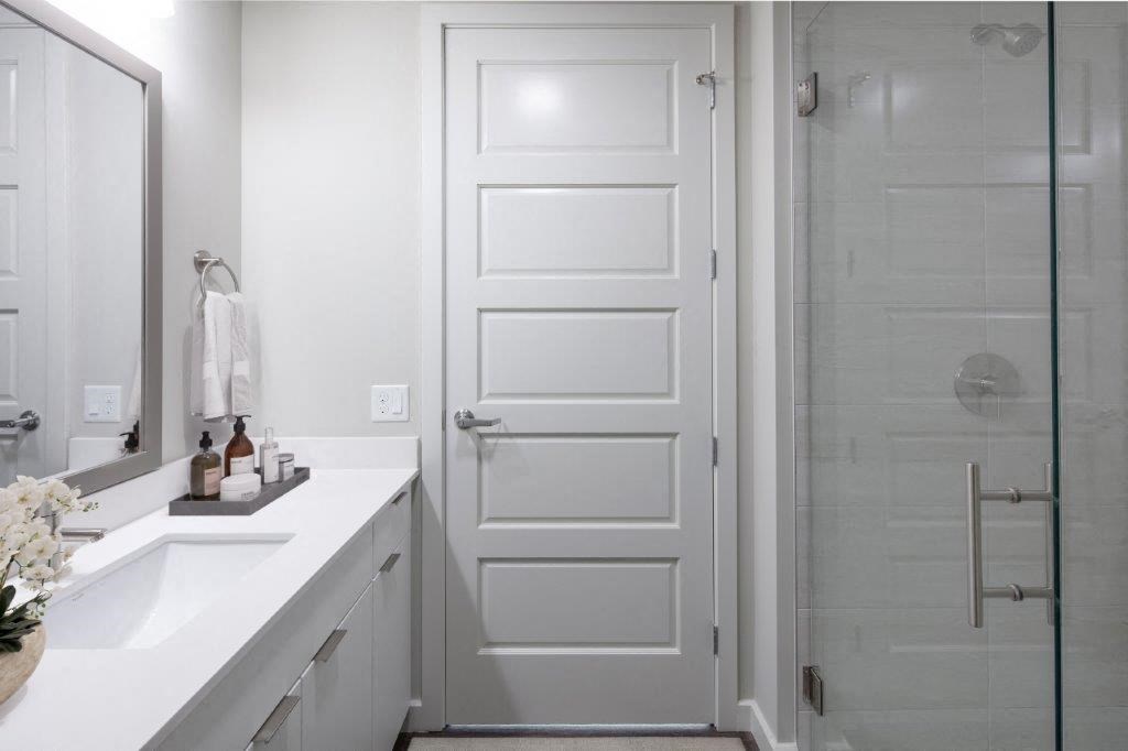 a white bathroom with a sink and a shower