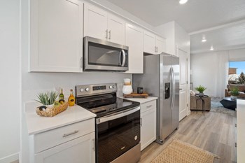 a kitchen with white cabinets and stainless steel appliances - Photo Gallery 3