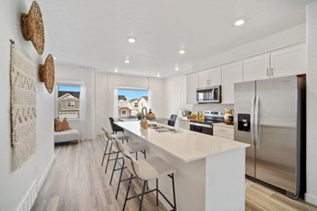 a kitchen with a large white counter top and a stainless steel refrigerator - Photo Gallery 2