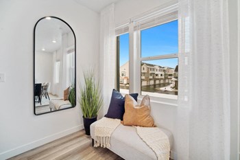 a seating area with a large mirror in front of a window - Photo Gallery 5