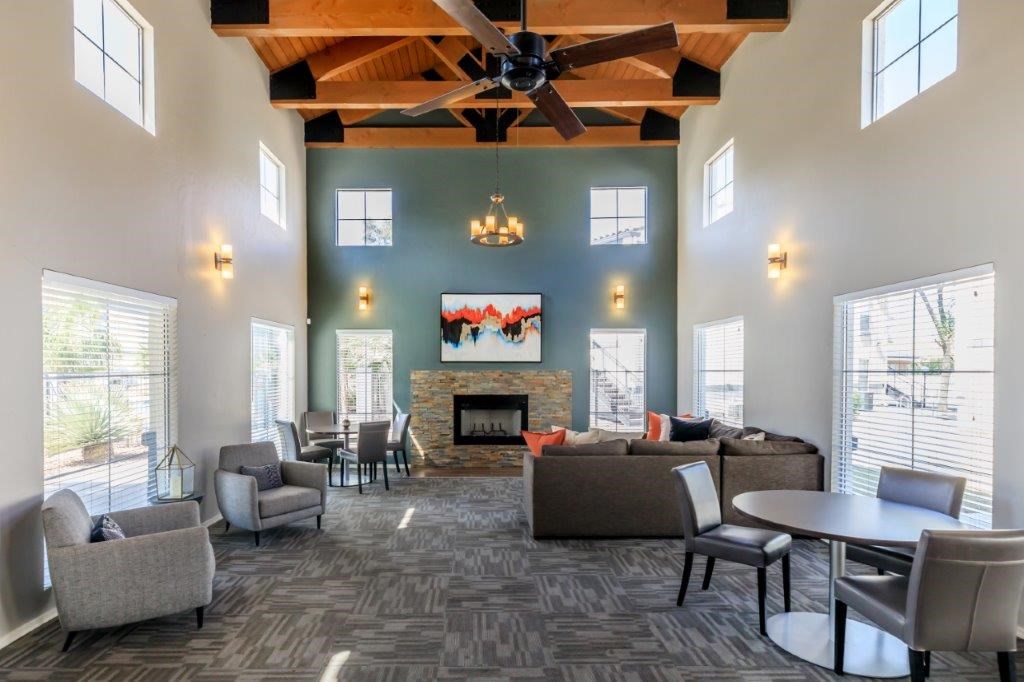 A spacious living room with a fireplace and a ceiling fan.