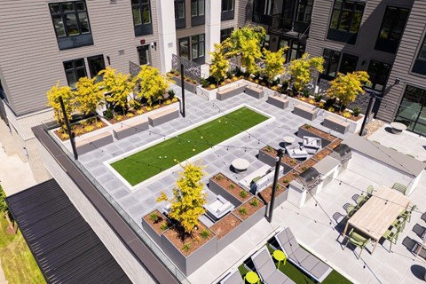 an aerial view of a courtyard with tables and chairs and grass