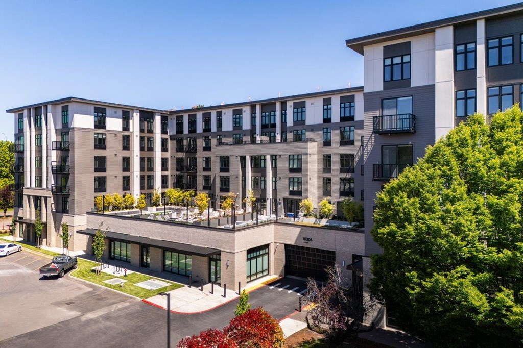 an aerial view of a building with trees and a parking lot