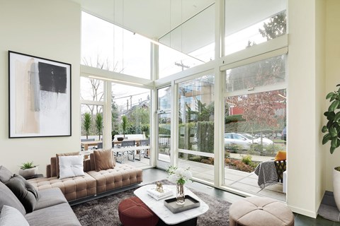 a living room with large windows and a couch and a table