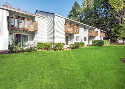 Private balconies and beautiful green grass behind apartments  Heron Hills apartments in Gresham Oregon.