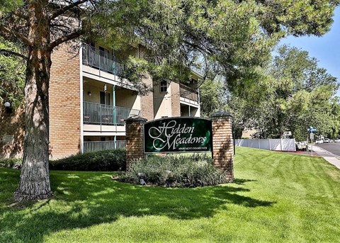 an apartment building with a sign in the grass