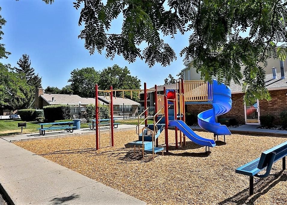 a playground with a blue slide in a park