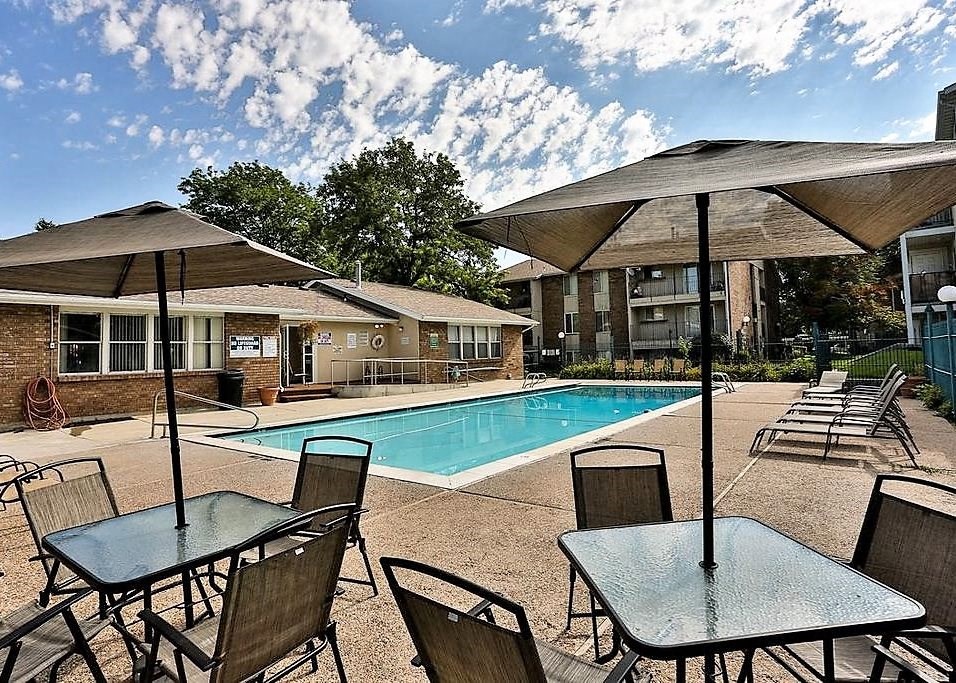 a swimming pool and tables with umbrellas