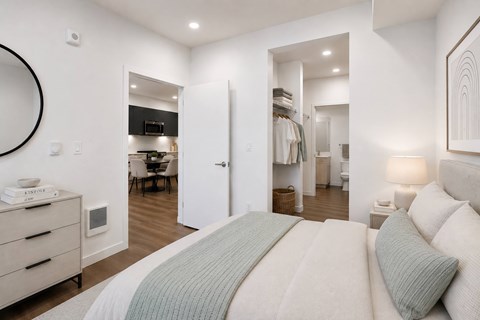 A bedroom with a large bed and a mirror on the wall.