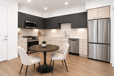 A modern kitchen with a round table and chairs.