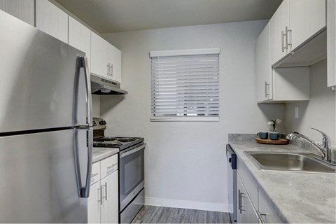 a kitchen with stainless steel appliances and white cabinets