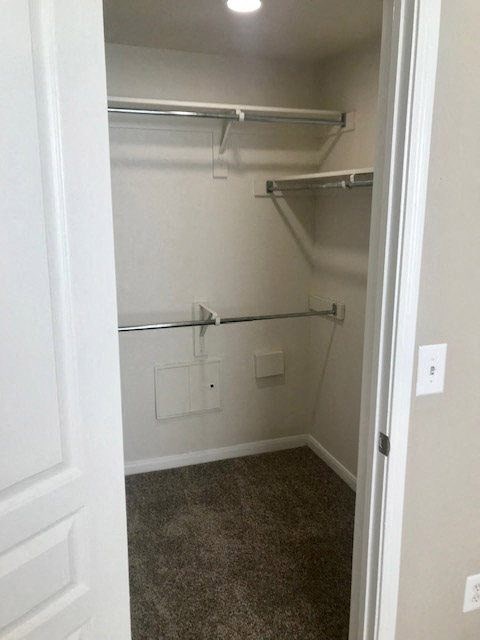 an empty closet with a white wall and a door