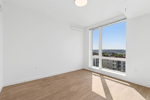 A room with a large window overlooking a cityscape.