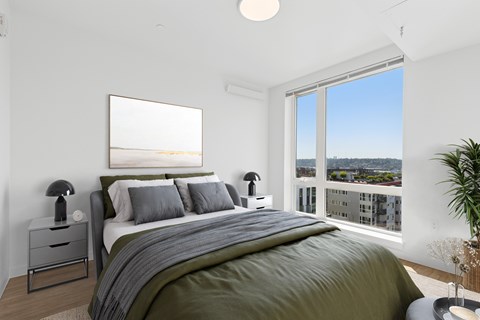 A bedroom with a large bed and a view of the city.