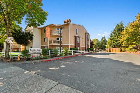 A sunny day at the entrance of a residential building named Cacadia Point.